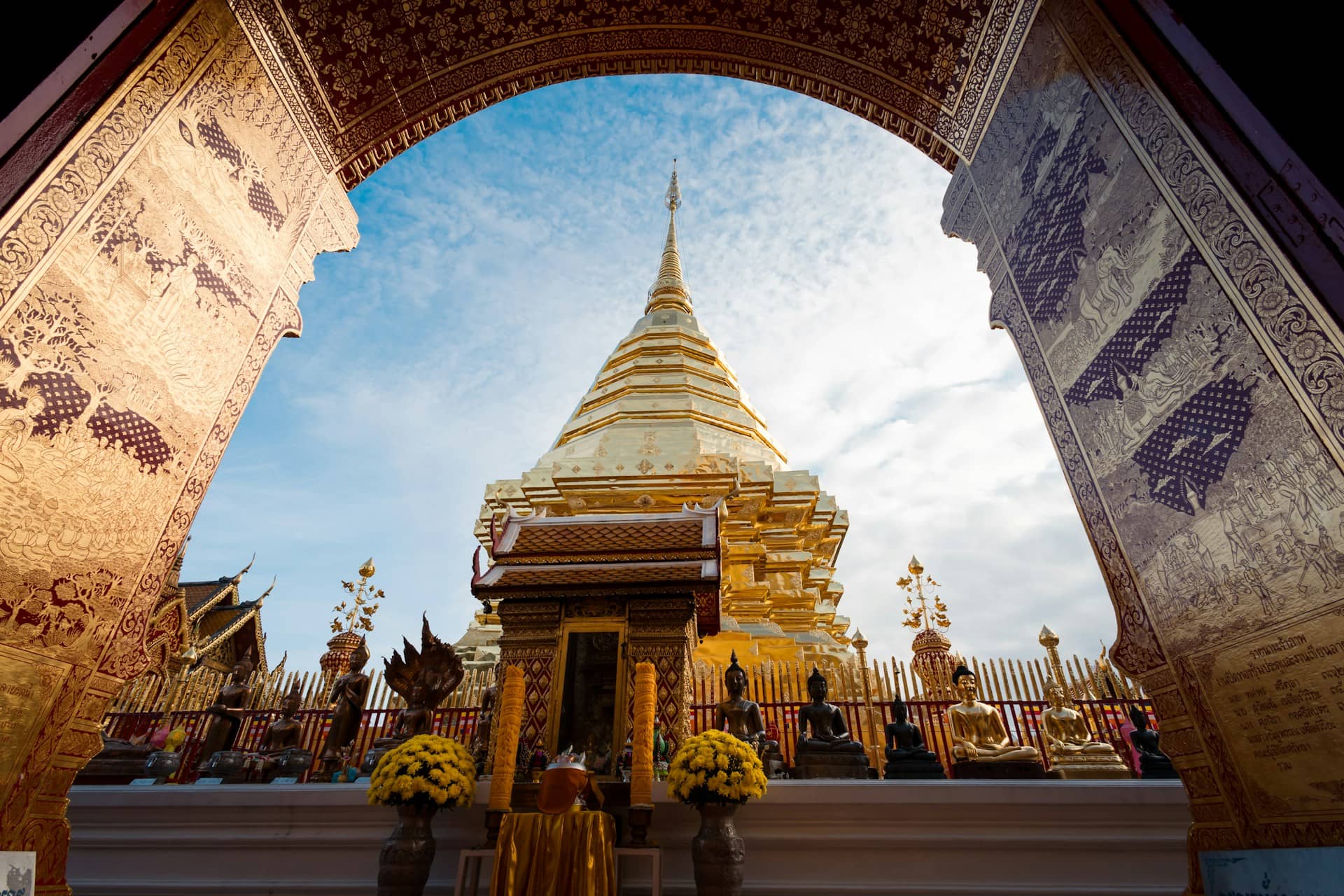 An arch leading into a temple with a sky in the background | Doi Suthep, Chiang Mai